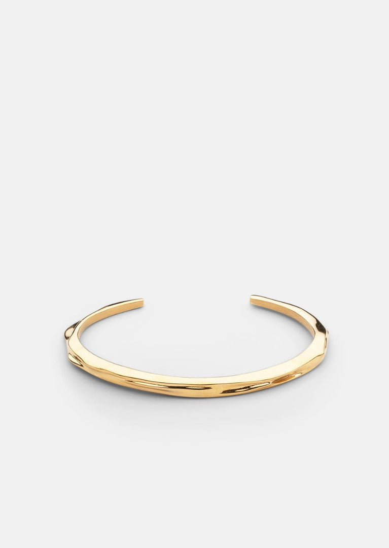 Gold-plated Opaque Objects Cuff bracelet by Skultuna, showcasing a sleek, minimalist design in a close-up shot.