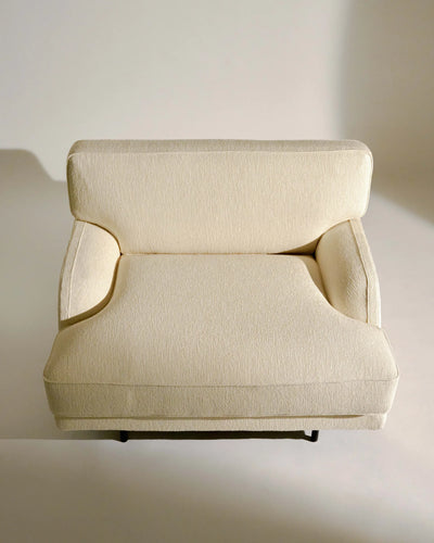 Gubi Flaneur Lounge Chair with boucle upholstery, modern seating with a curved design and wooden legs, stylish and comfortable.