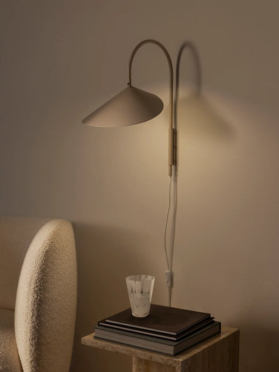 Arum Swivel Wall Lamp by Ferm Living, modern lighting fixture with adjustable arm, mounted on a wall in a contemporary interior.