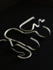 Ferm Living Curvature Hook in black, a stylish wall-mounted accessory for hanging items, with a sleek, curved design.