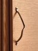 Ferm Living Curvature Handle in natural wood finish, modern accessory for furniture or cabinetry, with smooth curved design