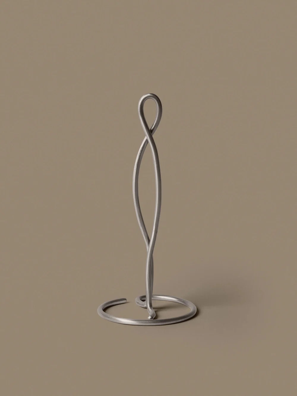 Ferm Living Curvature Paper Towel Holder in black with curved metal design for kitchen or bathroom accessories.