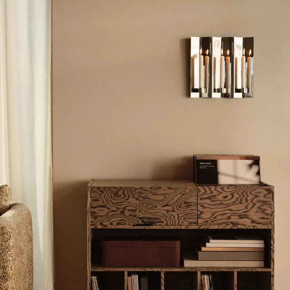 Ferm Living Eddy 3 Wall Candle Holder in black, with three candle slots and minimalist design, mounted on a wall.