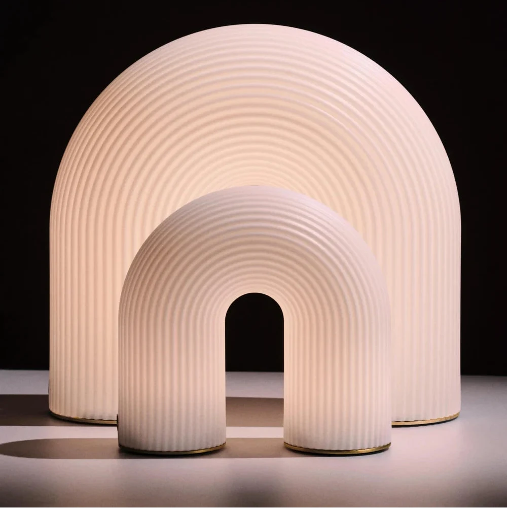 Ferm Living Vuelta outdoor portable lamp with sleek design, illuminated for outdoor lighting, featuring a modern, minimalist style.