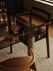 Ferm Living Boda dining chair with armrests, modern seating with wooden legs and upholstered seat and backrest.