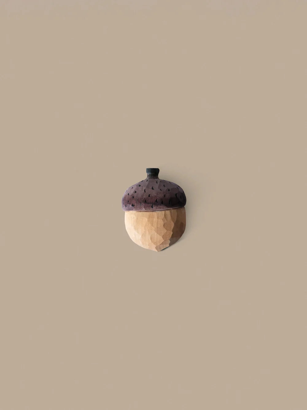 Hand-carved Ferm Living hook used as a wall accessory, showcasing natural wood craftsmanship and functional design.