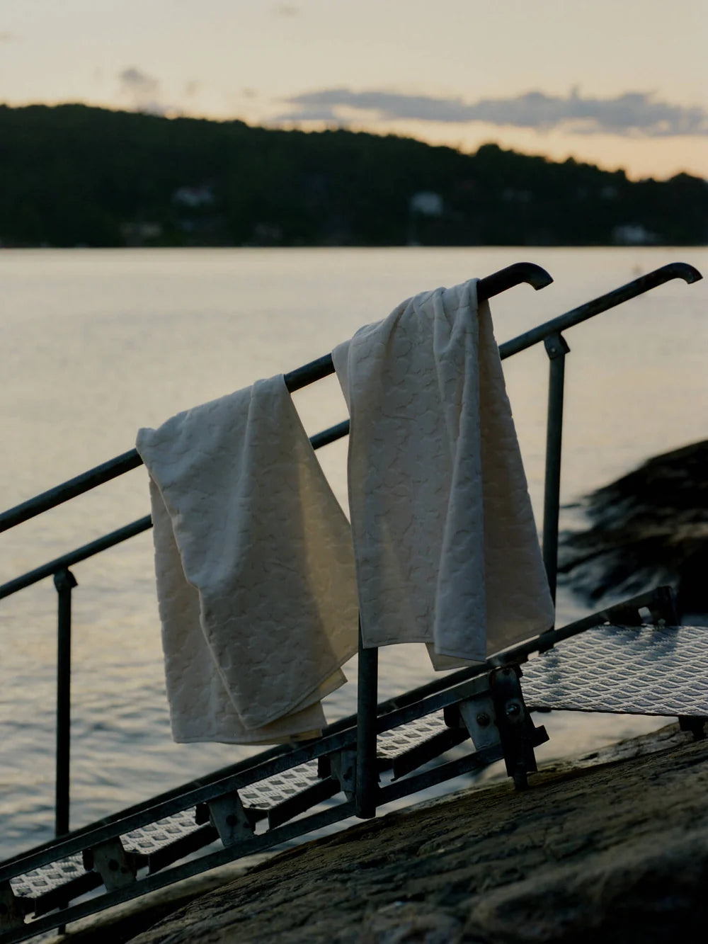Ferm Living Cilla Towel, soft fabric accessory with colorful striped design, displayed folded on a wooden surface.