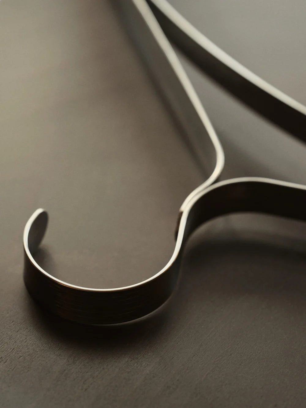 Set of three Ferm Living Bowline clothes hangers, minimalist accessories with sleek wooden design for hanging garments.