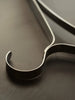 Set of three Ferm Living Bowline clothes hangers, minimalist accessories with sleek wooden design for hanging garments.