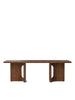 Androgyne Lounge Table by Audo Copenhagen with walnut finish, showcasing its sleek, modern design and smooth surface.