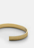 Gold plated ribbed cuff bracelet by Skultuna, featuring textured design and sleek metallic finish, styled as a fashionable accessory.
