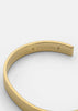 Gold plated ribbed cuff accessory by Skultuna, featuring textured design and metallic finish, styled on a wrist.