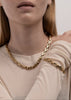 Gold plated Velo Chain bracelet by Skultuna, featuring a sleek chain design, worn on a wrist with accessories.