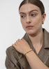 Gold plated Relier Nano bracelet by Skultuna, shown on a white background with a sleek, minimalist design.