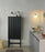 High Rib Cabinet by Normann Copenhagen in soft black with dark brown Hinx lamp, showcasing modern storage design.