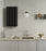 Rib Wall Cabinet by Normann Copenhagen in soft black, mounted on a wall, styled with dark brown Hinx lamp and decorative items.