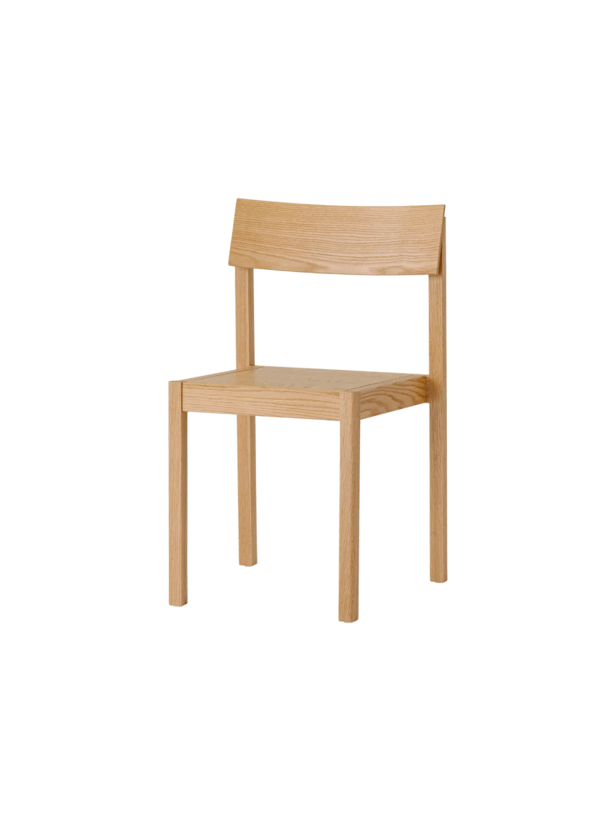 Mauro dining chair by Audo Copenhagen with natural oak veneer seat and sleek wooden frame, shown at an angle.