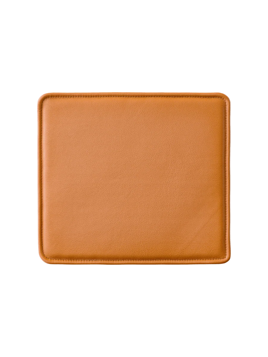Audo Copenhagen Mauro leather seat cushion in cognac color, designed for comfortable seating with a stylish appearance.