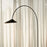 Ferm Living Arum Arched Floor Lamp with sleek metal arch and modern lighting design, standing tall in a contemporary interior setting.