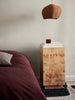 Burl side table by Ferm Living featuring a round top and wooden legs, ideal for modern living room decor.