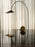Ferm Living Arum arched floor lamp with a sleek metallic finish and a curved arm, ideal for modern living room lighting.