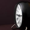 Roman table clock by Arne Jacobsen, minimalist accessory with sleek design, featuring a white dial and silver-tone case.