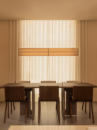 Hashira Linear Pendant Lamp by Audo Copenhagen hanging above a dining table, showcasing modern minimalist lighting design.