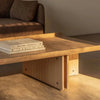 Audo Copenhagen Conrad lounge table with a sleek, modern design placed beside a cozy sofa in a stylish living room setting.