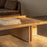 Audo Copenhagen Conrad lounge table with a sleek, modern design placed beside a cozy sofa in a stylish living room setting.
