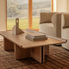 Audo Copenhagen Conrad lounge table with a sleek surface, paired with a textured tile rug and a modern lounge chair.