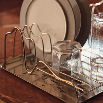 Ferm Living Curvature Dish Rack, modern black metal kitchen organizer with curved design and multiple slots for dishes and utensils.