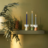 Three Eva Candle Holders by Bjørn Wiinblad displayed on a shelf, showcasing colorful, artistic ceramic accessories.