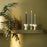 Three Eva Candle Holders by Bjørn Wiinblad displayed on a shelf, showcasing colorful, artistic ceramic accessories.