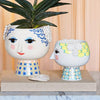 Bjørn Wiinblad Eva Flowerpot accessories displayed on a shelf, showcasing colorful floral ceramic designs by Bjørn Wiinblad.