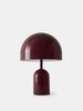 Tom Dixon Bell Portable Light in high-gloss burgundy finish, showing a sleek, rounded lighting design with a smooth, reflective surface.