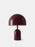 Tom Dixon Bell Portable Light in high-gloss burgundy finish, showing a sleek, rounded lighting design with a smooth, reflective surface.
