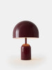 Tom Dixon Bell portable light in high-gloss burgundy, showcasing its sleek, rounded design and compact shape for modern lighting.