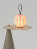 Red Filigrana Lantern table light by Established and Sons, featuring intricate design and warm illumination.