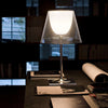 KTribe Table lighting by Flos featuring a modern design with a sleek base and adjustable arm, illuminated in a contemporary setting.