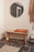 OYOY Mun wall mirror with natural wood frame, modern round design, mounted on wall in a stylish interior setting.