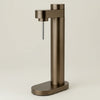 Bronze metallic Brus Carbonator accessory by Stelton, featuring sleek, modern design with textured metallic finish.