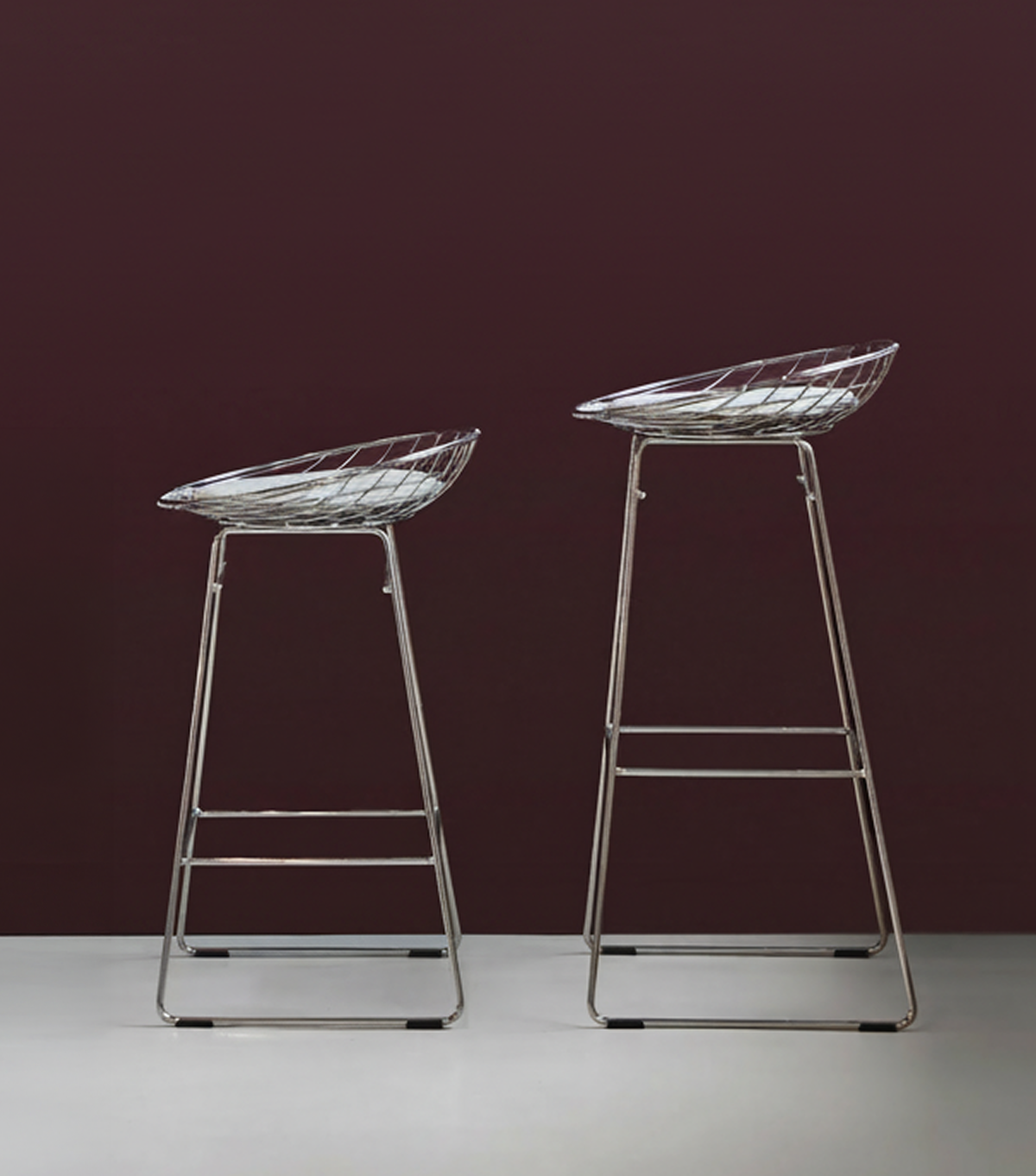 Pastoe KM06 Bar Stool Low, modern seating with wooden legs and a curved seat, displayed in a contemporary interior setting.