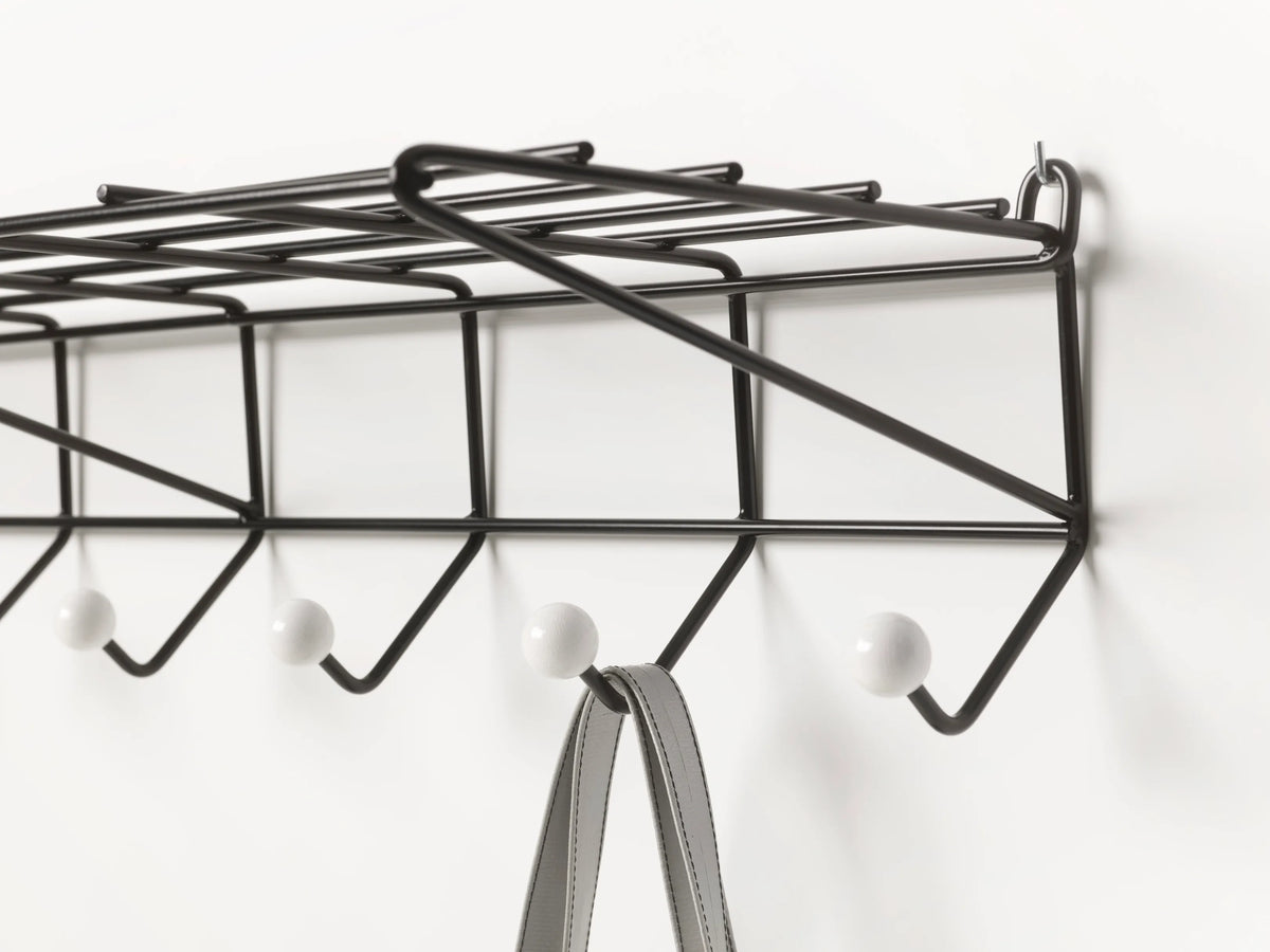 Black Pastoe DZ05 coat rack with hooks and a bag hanging, showcasing modern accessories design and functionality.