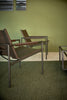 Pastoe SZ02 armchair with leather upholstery and wooden back frame, stylish seating piece for modern interior decor.