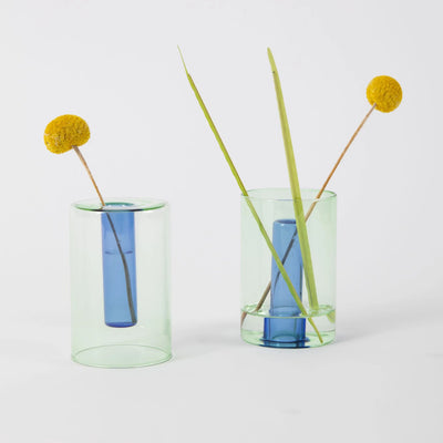 Small reversible glass vase in green and blue by Block Design, showcasing a sleek, modern accessory with a transparent, colorful design.
