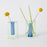 Small reversible glass vase in green and blue by Block Design, showcasing a sleek, modern accessory with a transparent, colorful design.