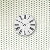 Roman wall clock by Arne Jacobsen showing a minimalist design with Roman numerals on a sleek wall.