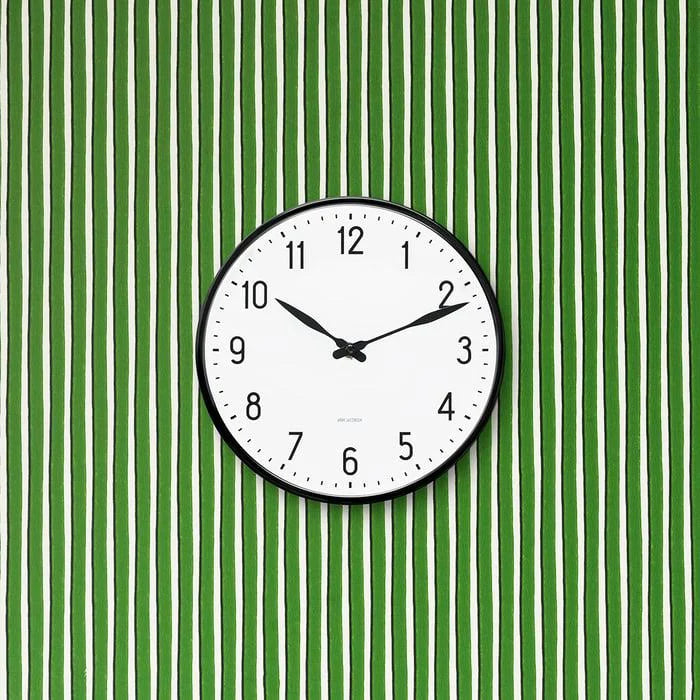 Arne Jacobsen Station wall clock with minimalist design, featuring a round face and sleek hands, mounted on a wall as a stylish accessory.