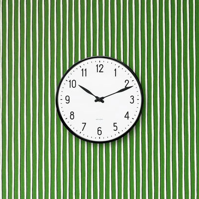 Arne Jacobsen Station wall clock with minimalist design, featuring a round face and sleek hands, mounted on a wall as a stylish accessory.