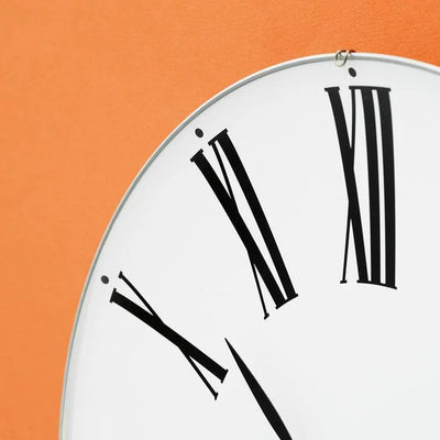Roman Wall Clock by Arne Jacobsen, minimalist accessories with a sleek round face and Roman numeral markings, mounted on a wall.